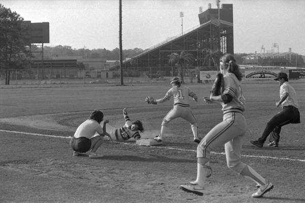 Coach Graff watches from sideline as player slides into third base - Tallahassee, Florida.