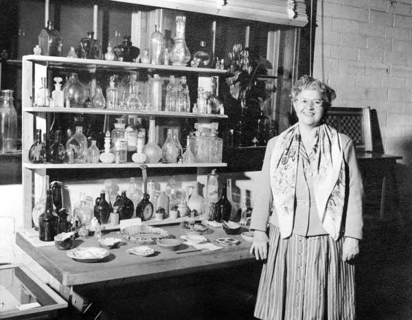 Storyteller Thelma Boltin standing next to a bottle collection at a hobby show in Gainesville, Florida.
