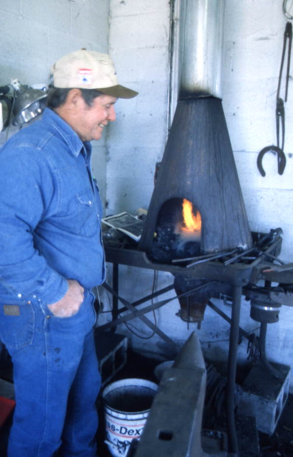 View showing Randy Minger at furnace blacksmithing horseshoes at the Spring Garden Ranch Training Center in De Leon Springs, Florida.