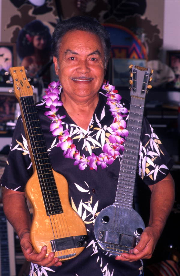 Portrait of Hawaiian steel guitarist Richard "Dick" Sanft holding a couple of guitars at his home in Kissimmee, Florida.