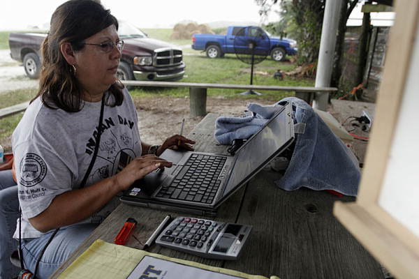 Leoma Simmons using a laptop computer for ranching operations at the Big Cypress Seminole Indian Reservation in Hendry County, Florida.