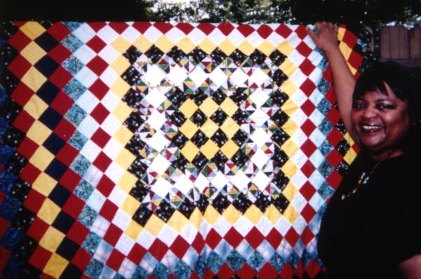 Patricia Inness with quilt made by her grandmother Rachel Sellers Cobb in Eatonville, Florida.