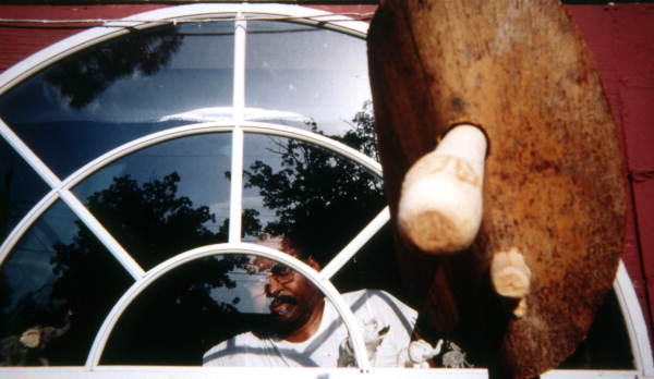 Eugene Cobb at the window with his palmetto sculpture in the foreground - Eatonville, Florida.