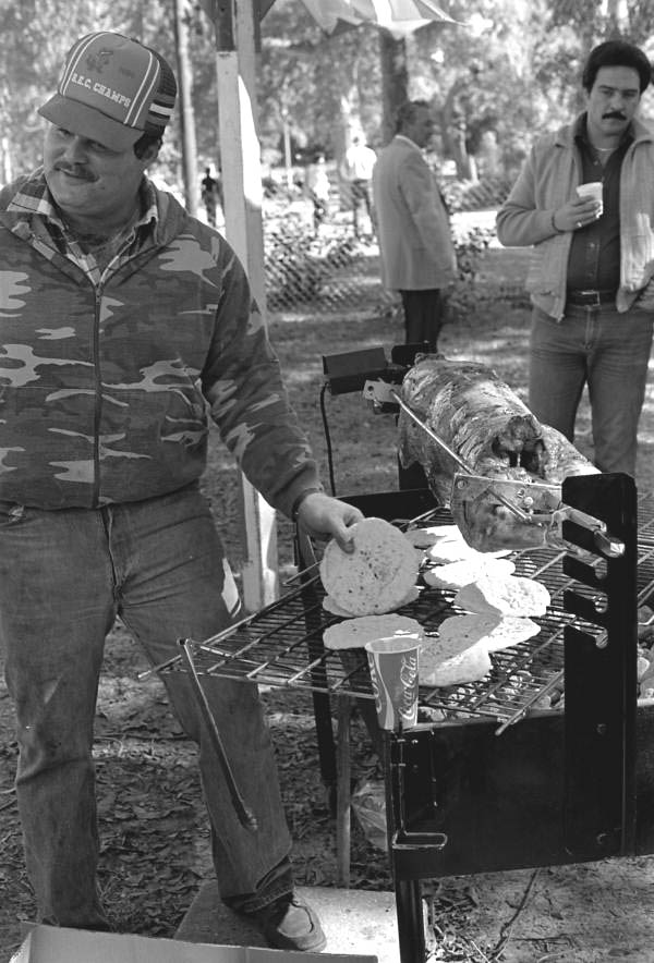 Greek American man cooking lamb at Epiphany Day glendi - Tarpon Springs, Florida