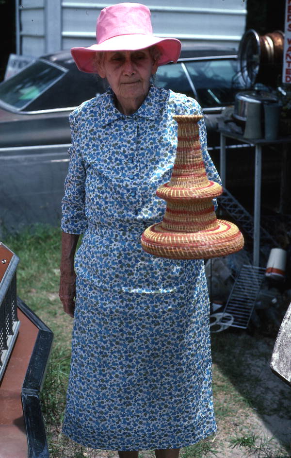Myrtle McCoey holding a pine needle craft she made