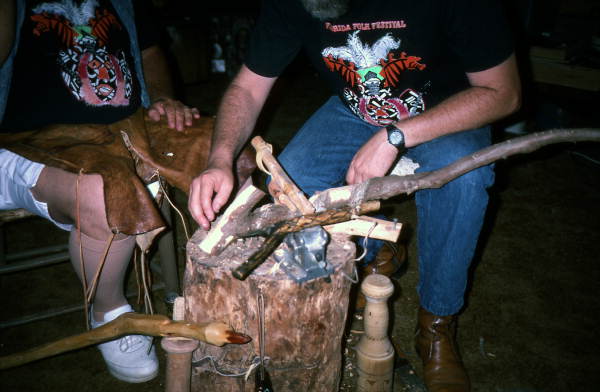 Bobby Johns and apprentice Randy Stewart stacking pieces of wood to make art