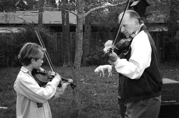 Apprentice Andrew Cook learning the art of twin fiddling from his mentor George Custer.
