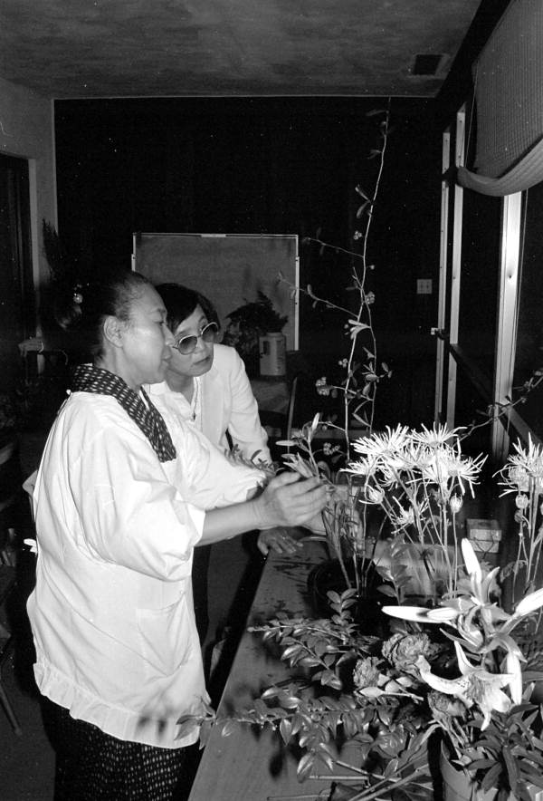 Sumino McGlamory observes as Atsuko Lefcourte makes Ikebana floral arrangement- Palm Beach, Florida.