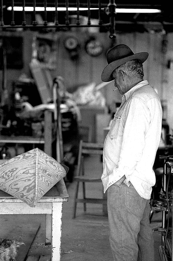 Glen Simmons looking over an Everglades skiff that he and an apprentice are making- Florida City, Florida.