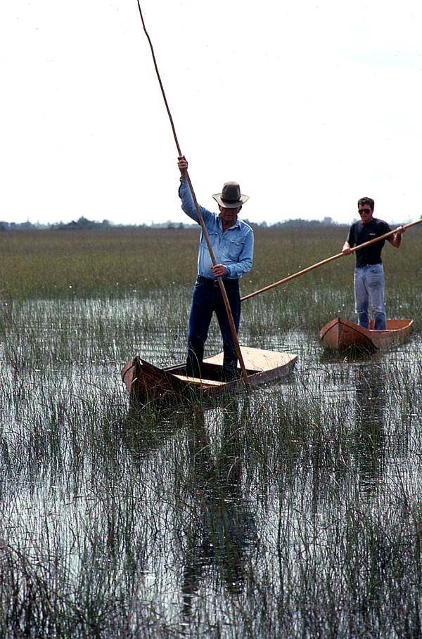 Glen Simmons (foreground) and apprentice Donald Edwards navigating their way through the "River of Grass" on glades skiffs- Florida City, Florida.