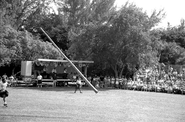 Man participating in "turning the caber" at Key Biscayne Scottish Games- Key Biscayne, Florida