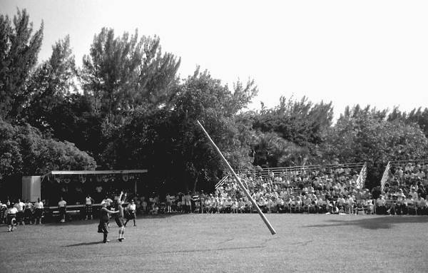 Man participating in "turning the caber" at Key Biscayne Scottish Games- Key Biscayne, Florida