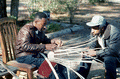Apprentice Michael Steen (R) watches teacher Alphonso Jennings make a white oak basket - Lamont, Florida