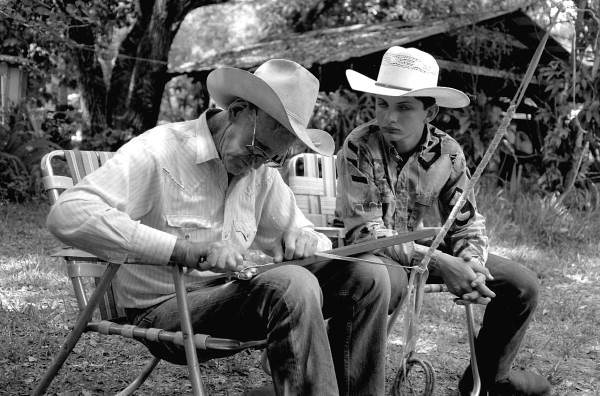 Cow whip maker George "Junior" Mills (l) works as his apprentice J. Taylor Marcus observes - Okeechobee, Florida.