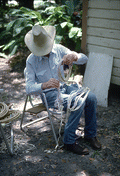 Cow whip maker George "Junior" Mills coiling sections of whip - Okeechobee, Florida.