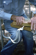 Cow whip maker George "Junior" Mills rolling a whip between blocks of wood - Okeechobee, Florida.