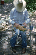 Cow whip maker George "Junior" Mills rolling a whip between blocks of wood - Okeechobee, Florida.