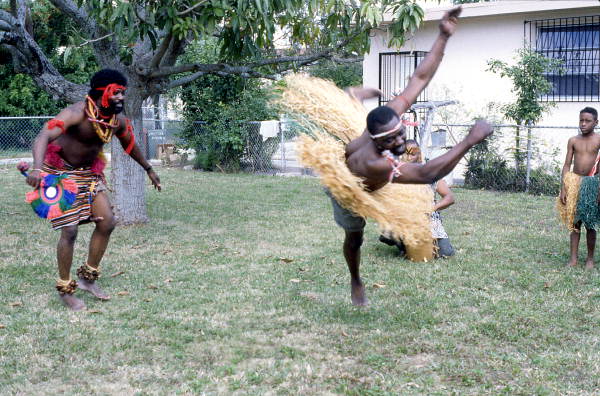 Nigerian acrobatic dancer Felix Omeben performs as Augustine Omeben (l) looks on - North Miami, Florida