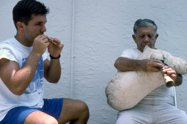 Greek bagpipe player Nikitas Tsimouris, right, plays the tsabouna, accompanied by his apprentice and grand-nephew Nikitas Kavouklis on the practice chanter - Tarpon Springs, Florida