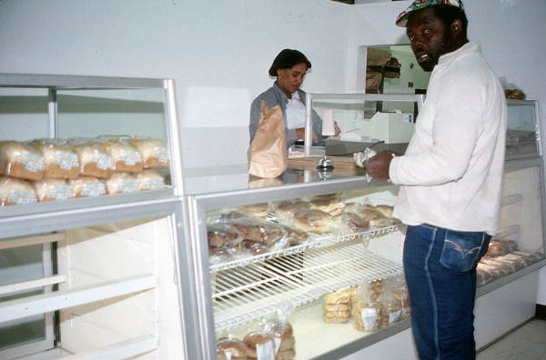 Customer at the sales area of the Jamroc Bakery buying Jamaican baked goods - Belle Glade, Florida.