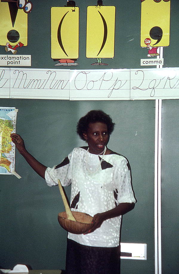 Haitian storyteller Liliane Nerette-Louis, holding bowl and utensil, visiting elementary class - Boynton Beach, Florida.