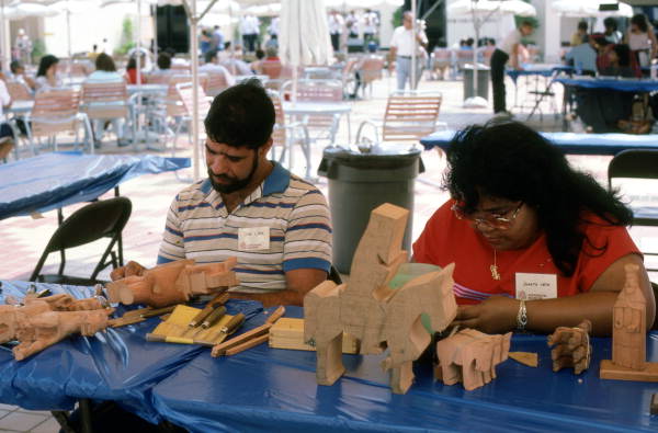 Jose Orta and unidentified artisan demonstrating wood-carving at the Traditions Festival - Miami, Florida.