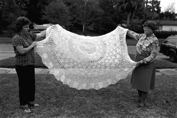 Maria Birchfield and Benia Birchfield holding up a pineapple crochet tablecloth - Saint Augustine, Florida