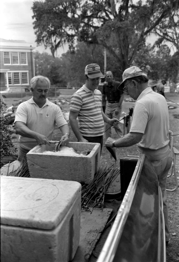 Men putting mullet fish on forks for smoking - Monticello, Florida