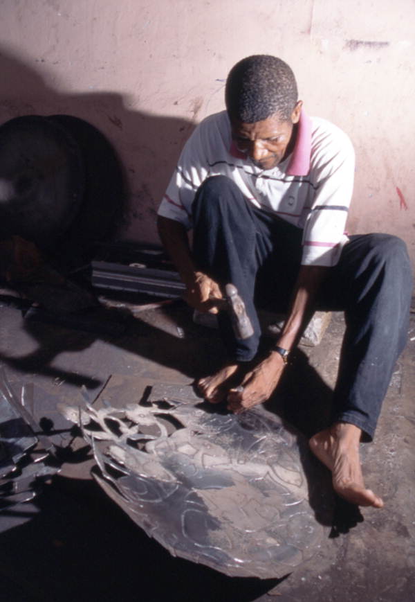 Almann Ulysee works on a piece of metal - Miami, Florida.