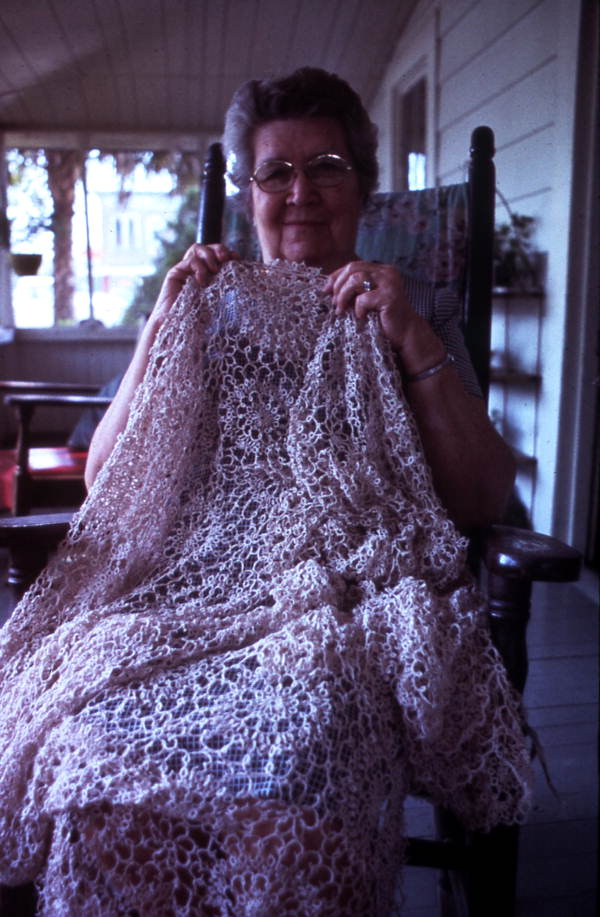 Woman holding up her tatting item