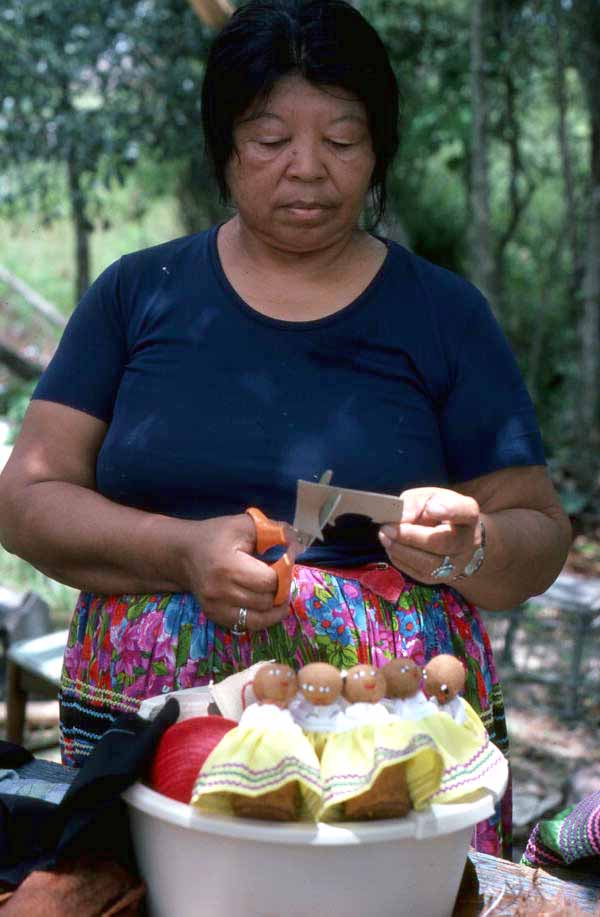 Mary Billie cutting cardboard to make hair for her Seminole dolls - Big Cypress Reservation, Florida