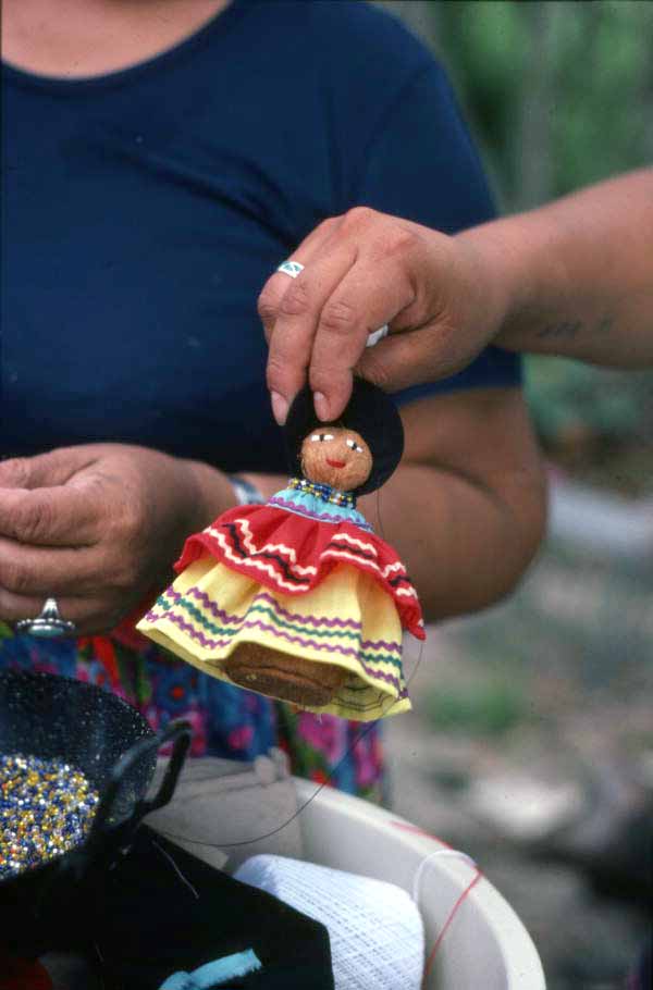 Seminole doll made by Mary Billie being held up for the camera - Big Cypress Reservation, Florida