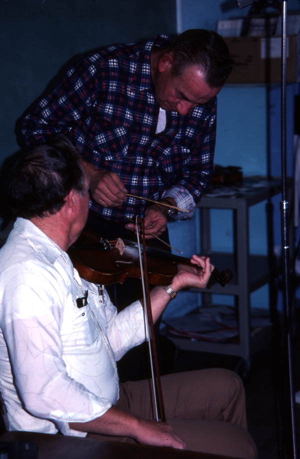 Harold Sconyers fiddling while Buddy Huggins "banjos" on the strings - Lake City, Florida.