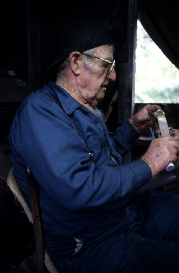 Knife maker Loys Cain checks the shape of a blade - Eastpoint, Florida