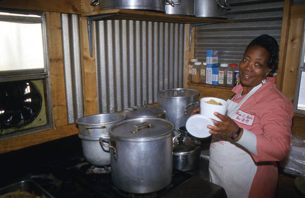 Pleasant Jenkins putting pilau rice into a styrofoam container - Jacksonville, Florida
