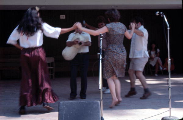 Nikitas Tsimouris playing a tsambouna while Greek dancers perform around him - White Springs, Florida