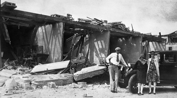 Two women and a man standing in front of wreckage caused by the hurricane of 1926