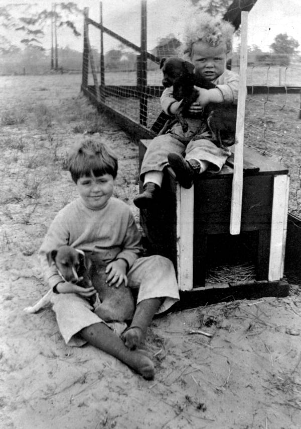 Virginia and Bub Ahern playing with puppies - Babson Park, Florida