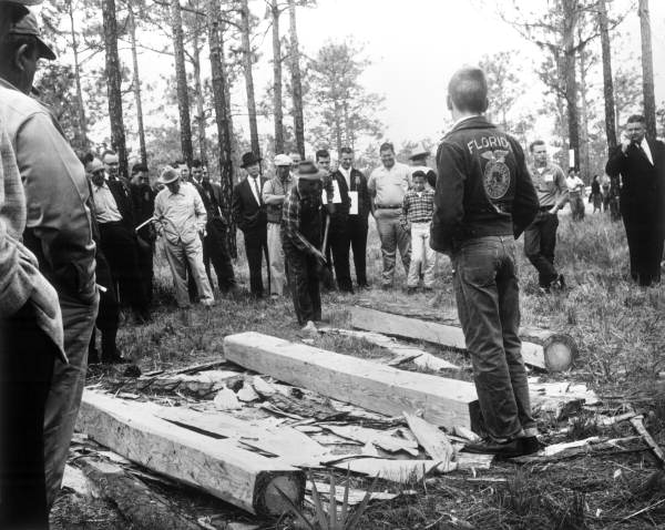 Demonstration broad ax hewing of logs at a 1960 FFA meeting .