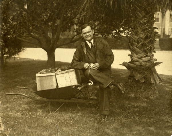 Governor John Martin peels an apple under the trees