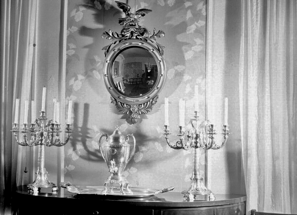 Mirror, silver candlesticks and silver urn