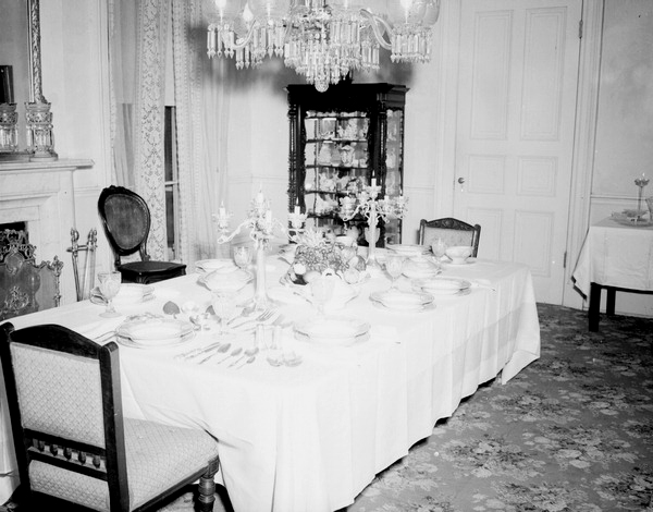 Dining room table with tableware and silverware sets on display at Goodwood