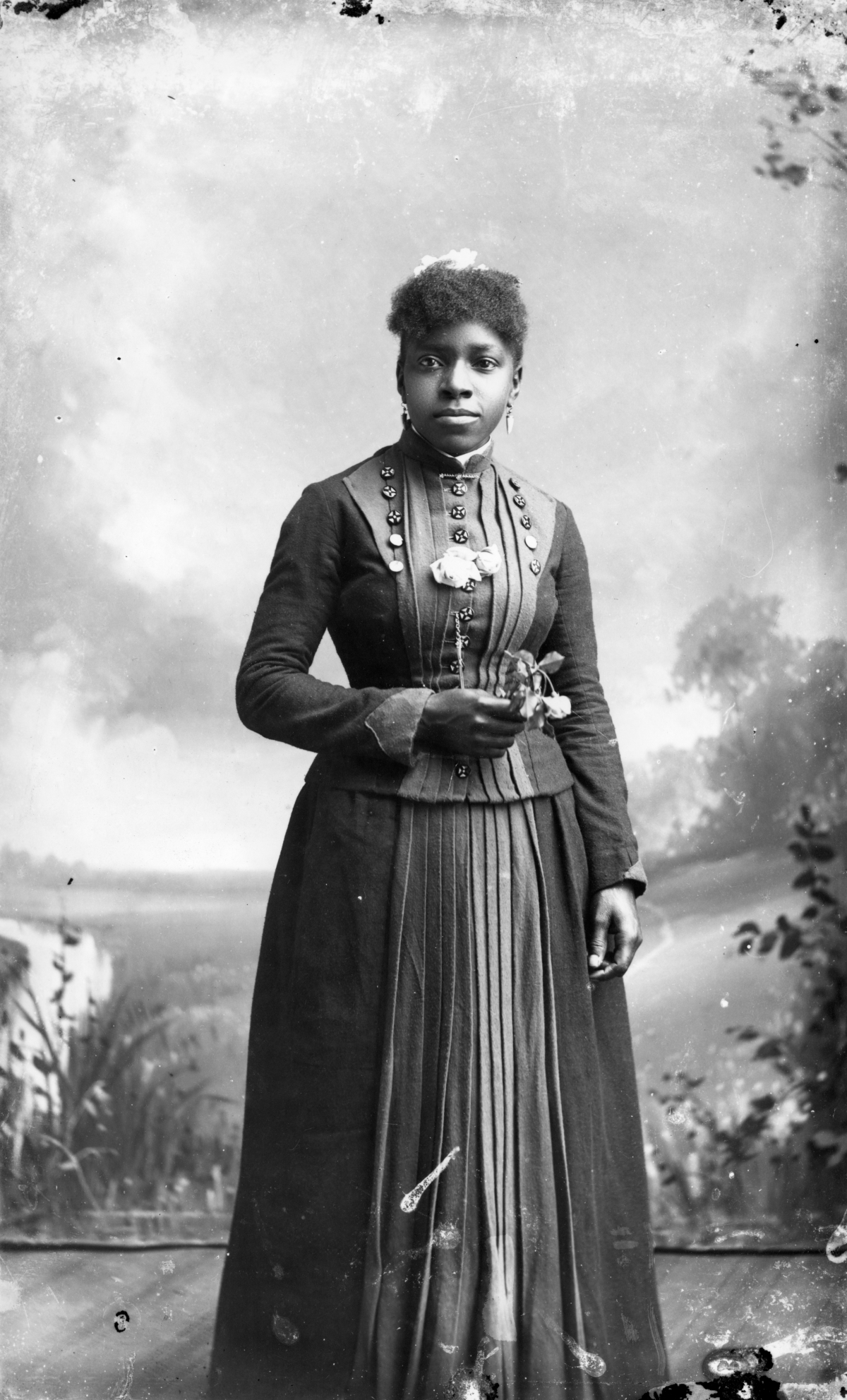 Woman holding a wilting rose.