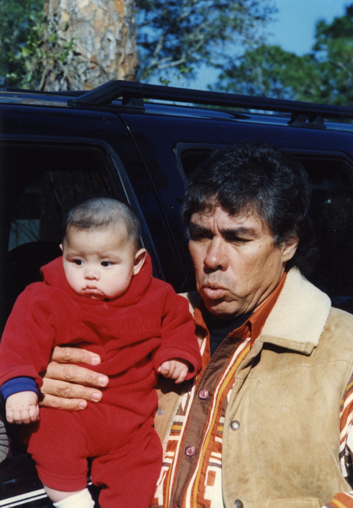 James Billie with infant at the Brighton Seminole Reservation tribal rodeo.