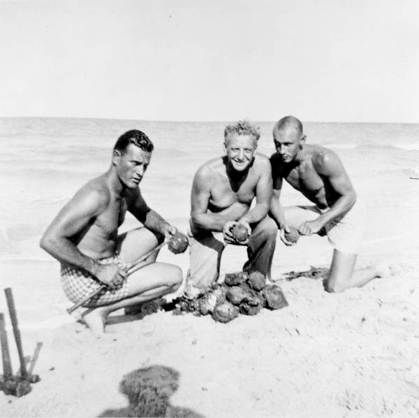 Treasure hunter Art McKee and fellow divers on the beach with cannonballs