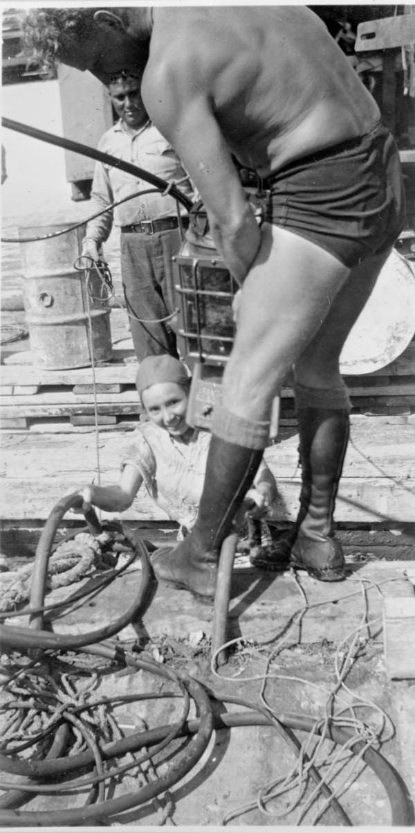 Gay McKee being fitted with diving helmet by husband Art