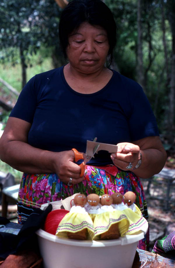 Mary Billie cutting cardboard to make hair for her Seminole dolls: Big Cypress Seminole Indian Reservation, Florida