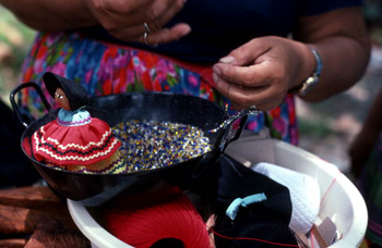 Mary B. Billie making a necklace for her Seminole doll: Big Cypress Seminole Indian Reservation, Florida