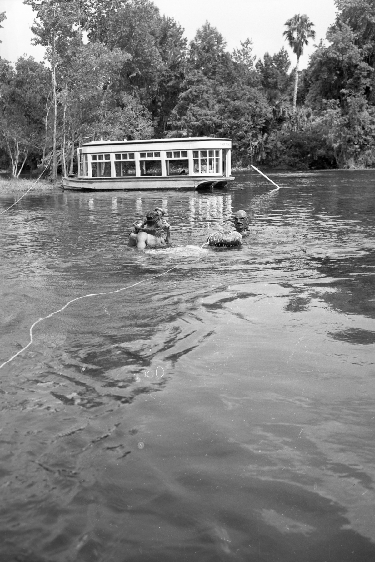 Diver and creature character in the water during filming of "Revenge of the Creature" movie.