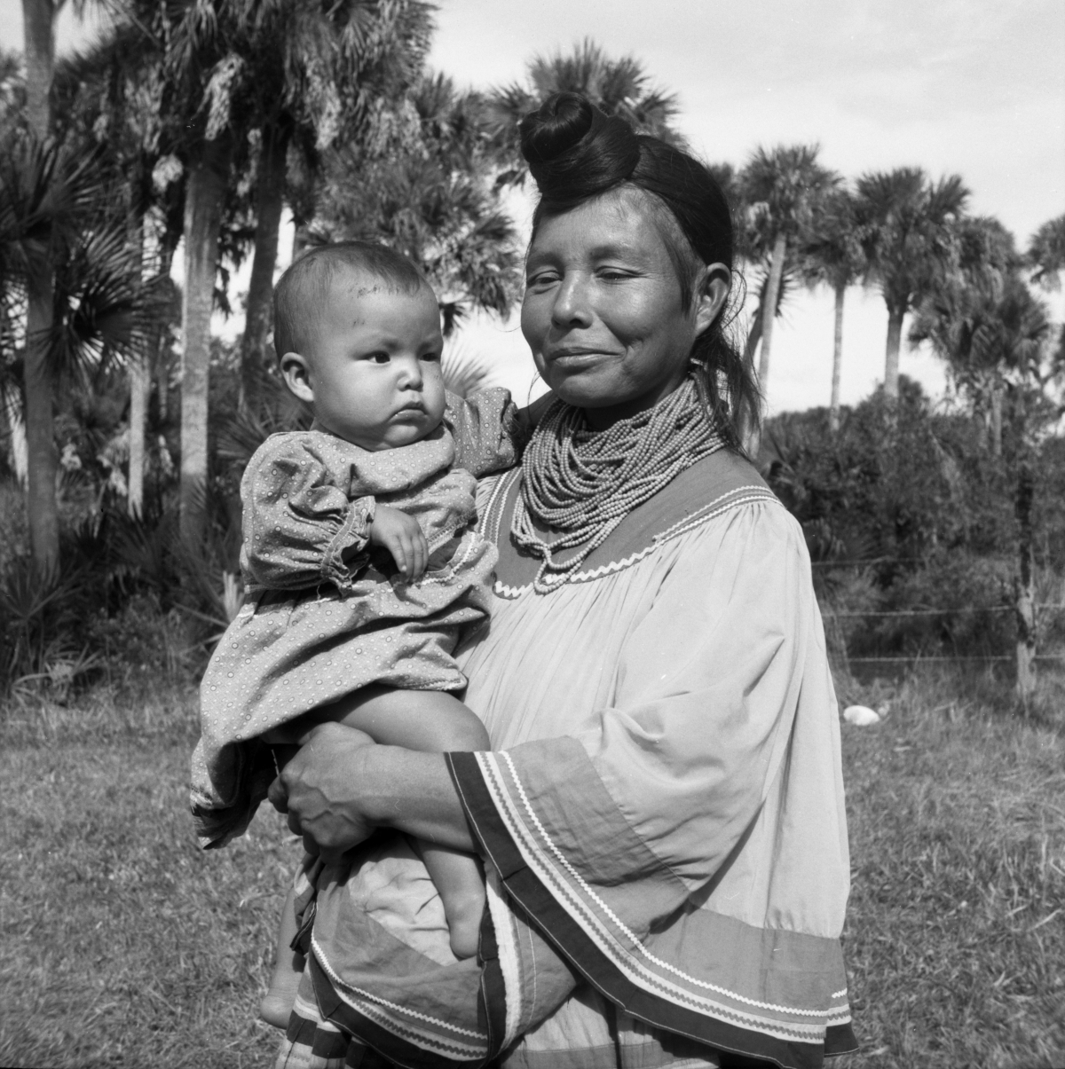 Seminole woman Leona Smith holding a child